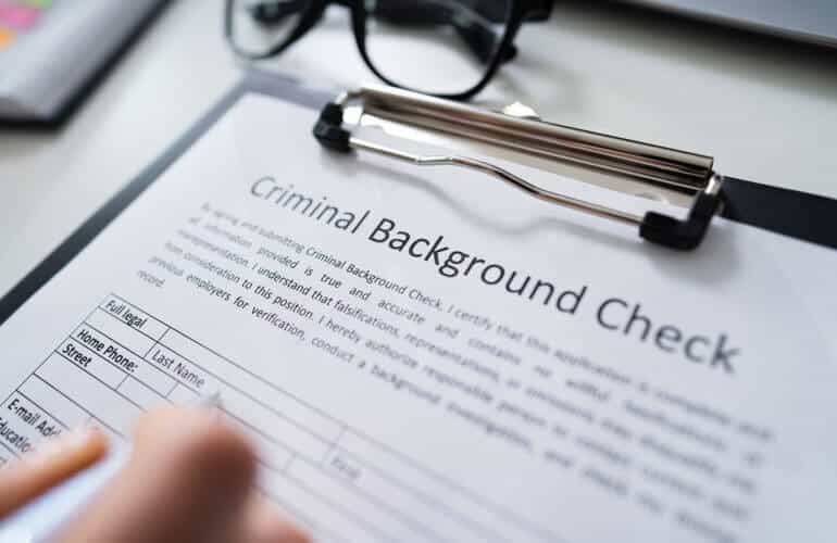 A person is filling out criminal background check form.